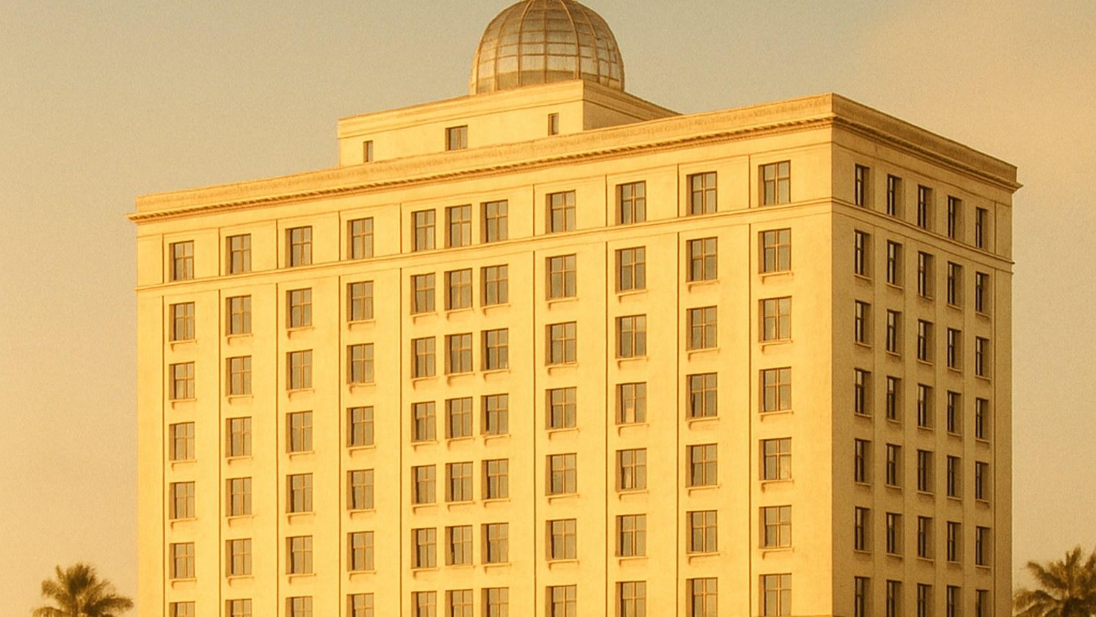 A grand 1920s hotel tower with a glowing glass dome over Biscayne Bay at golden hour